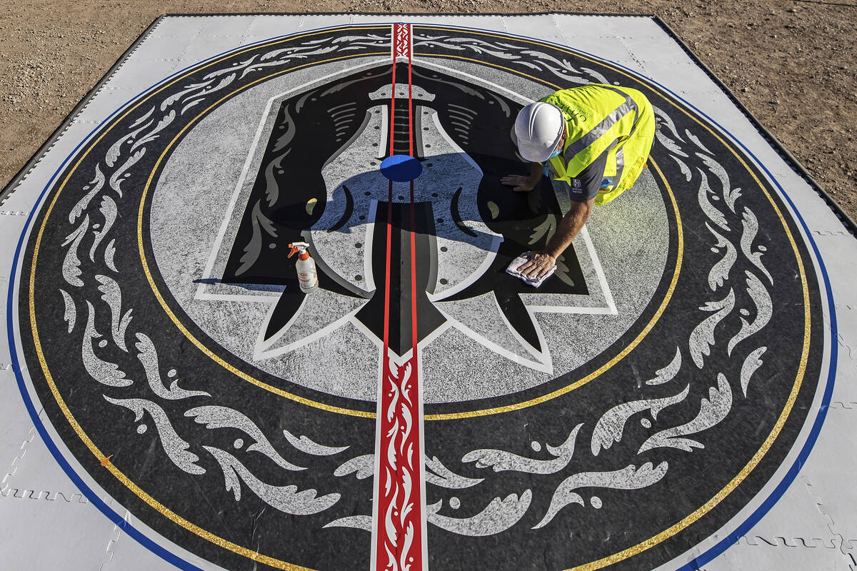 Construction workers put the finishing touches on the Henderson Silver Knights logo during a co ...