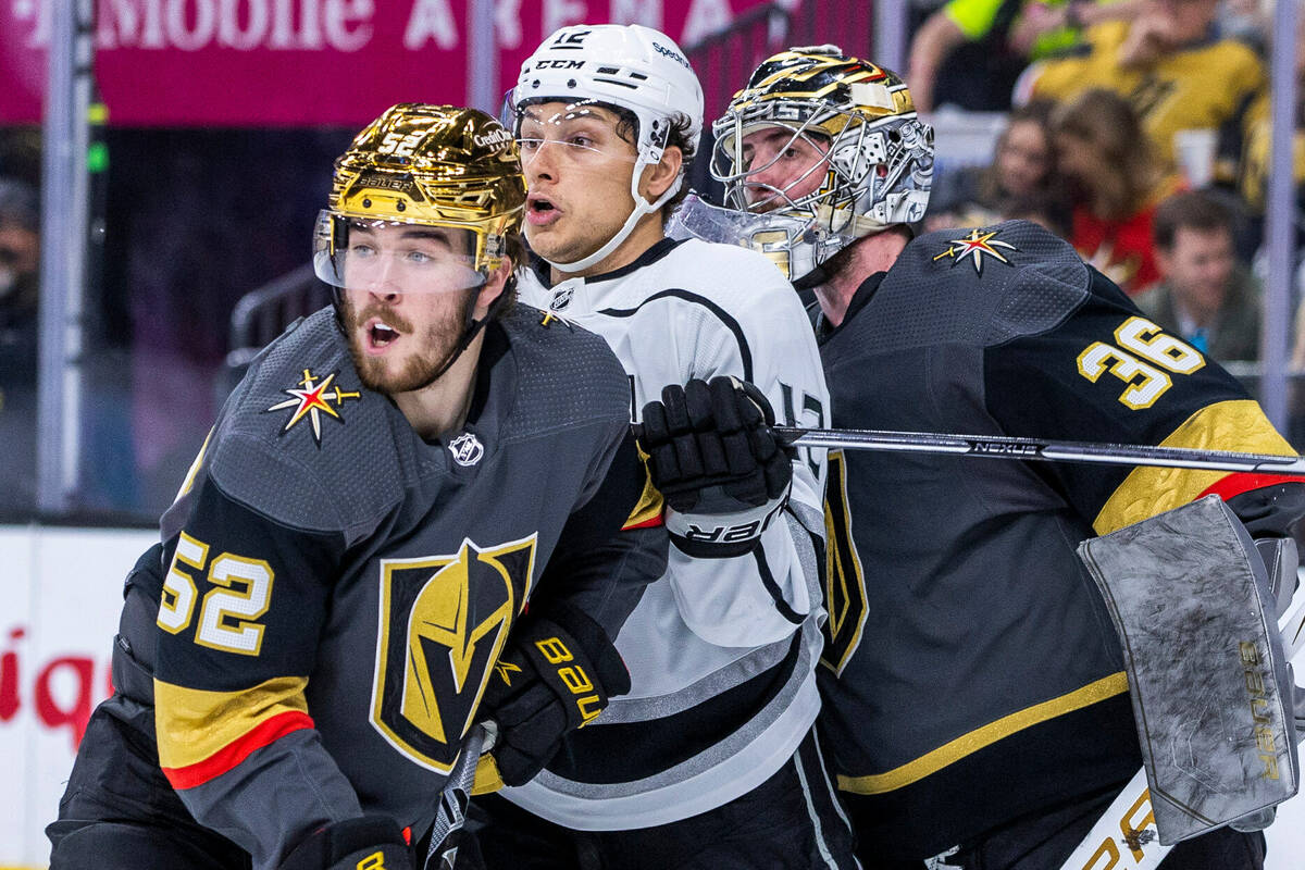 Golden Knights defenseman Dylan Coghlan (52) and Los Angeles Kings center Trevor Moore (12) bat ...