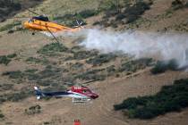 Two helicopters pass while fighting a wildfire in Springville on Monday, Aug. 1, 2022. A Utah m ...