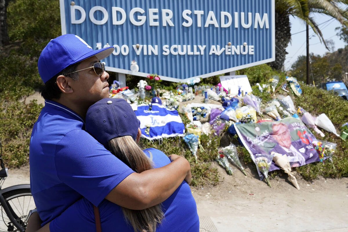 Chad Marshall, left, hugs his girlfriend Veronica Ramos at a makeshift shrine in honor of broad ...