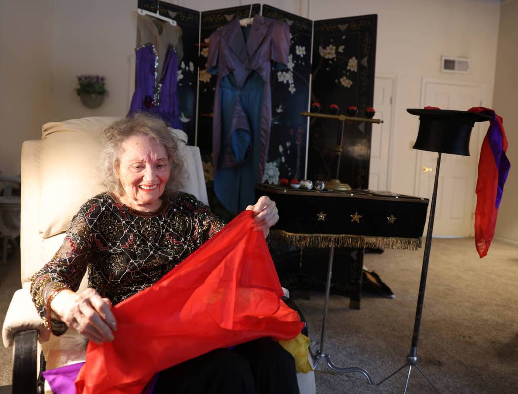 Magician Gloria Dea, 99, feels her old magic silks at her Las Vegas home Tuesday, Aug. 9, 2022. ...