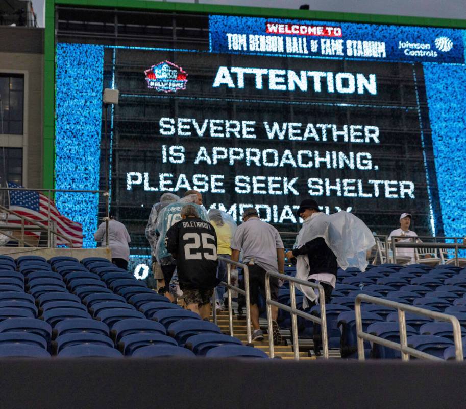 Fans leave their seats to seek shelter during a weather alert that delayed the start of the NFL ...