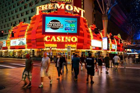 People cross Casino Center Boulevard outside of the Fremont Hotel Casino as hotel-casinos reope ...