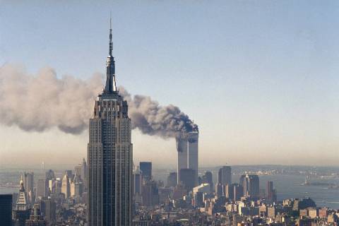 The twin towers of the World Trade Center burn behind the Empire State Building in New York on ...