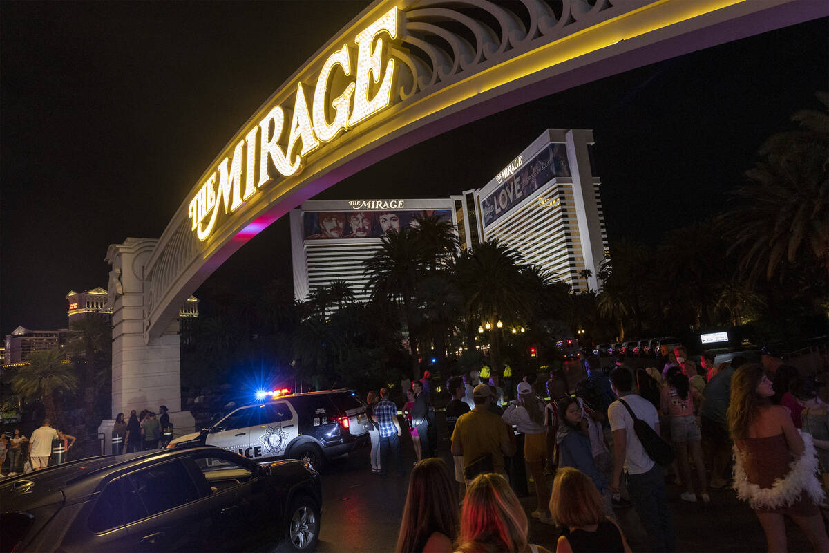 Pedestrians linger at The Mirage while Metropolitan police respond to a fatal shooting in the h ...