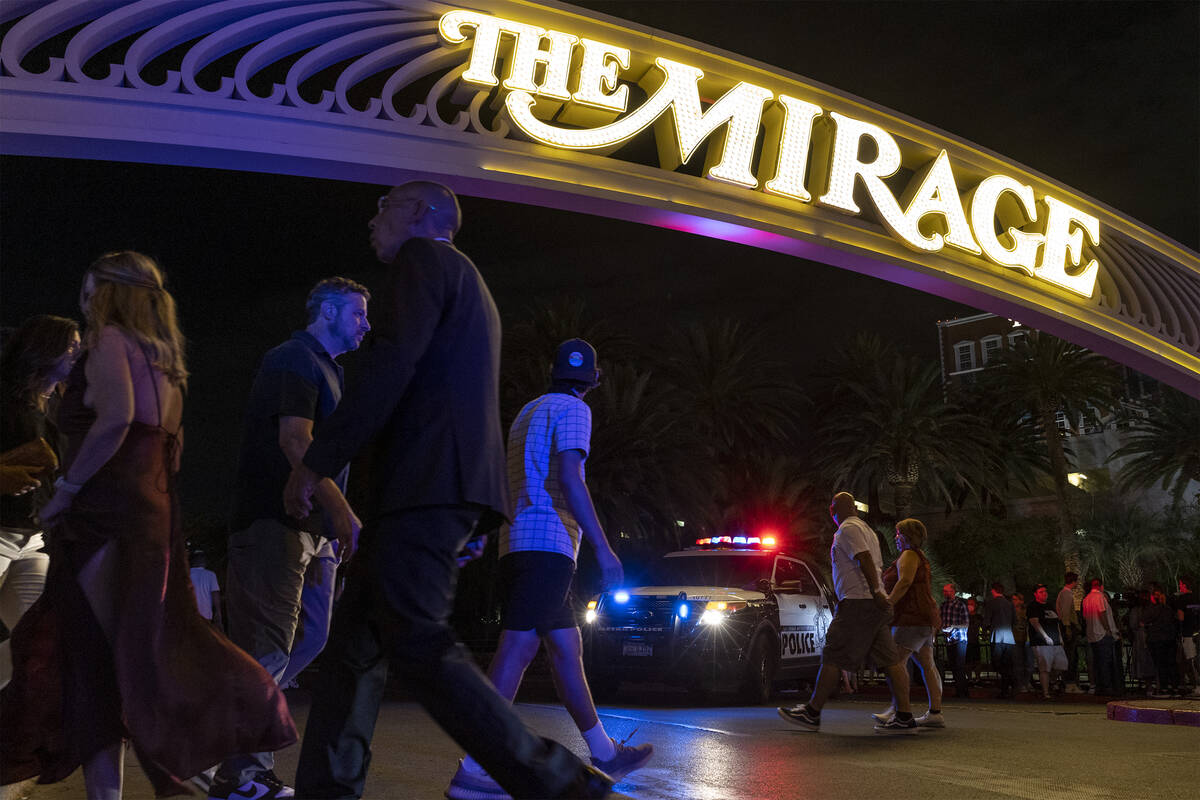 Pedestrians pass The Mirage while Metropolitan police respond to a fatal shooting in the hotel- ...