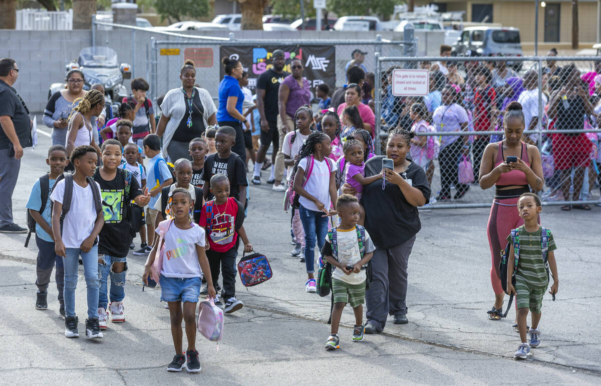 Students and parents enter for a red carpet welcome for their first day of school at Kelly Elem ...