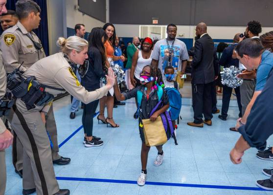 Las Vegas police officers join others in a red carpet welcome for students on their first day o ...