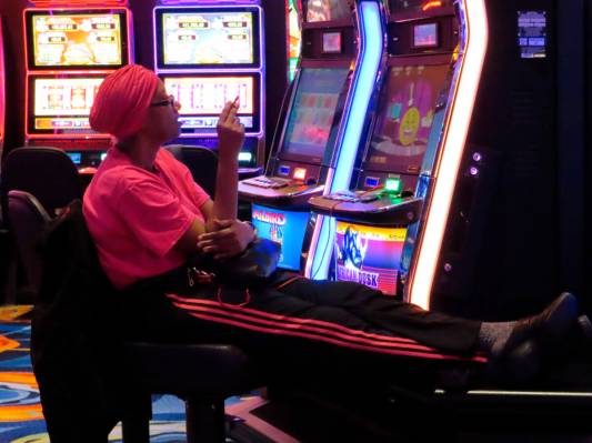 This Feb. 10, 2022, photo shows a gambler smoking while playing a slot machine at the Ocean Cas ...