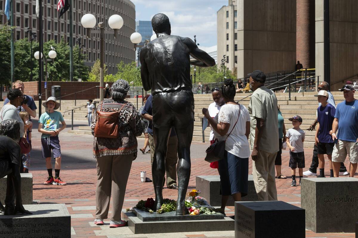 People gather to view a statue of Boston Celtics basketball great Bill Russell, Monday, Aug. 1, ...
