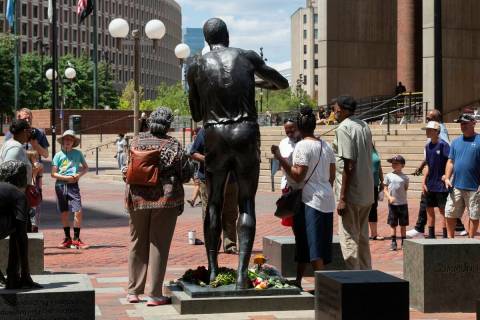 People gather to view a statue of Boston Celtics basketball great Bill Russell, Monday, Aug. 1, ...