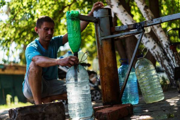 A resident fills up water bottles at a well in Sloviansk, Donetsk region, eastern Ukraine, Satu ...