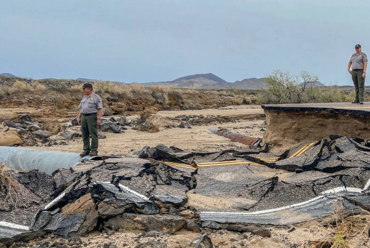 Park officials survey a road damaged by recent floods in Mojave National Preserve in August 202 ...