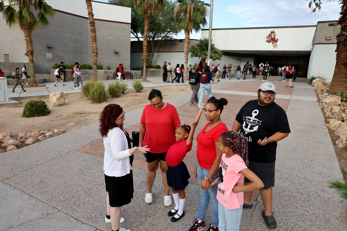 Teacher Jesica Benton talks to a family as students arrive at a single point of entry for the f ...
