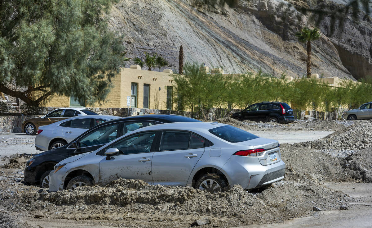 Cars remain stuck in mud flows in the parking lot of The Inn at Death Valley at the national pa ...