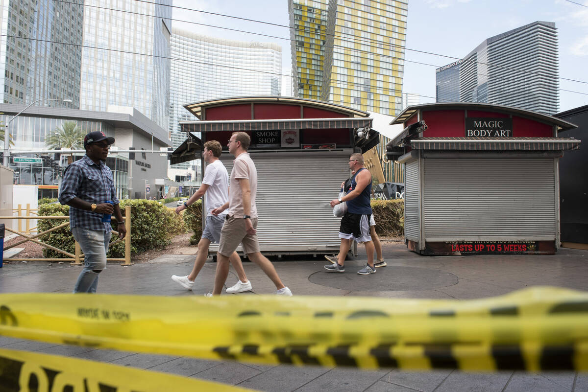 Pedestrians walk through the closed Hawaiian Marketplace on Las Vegas Boulevard on Monday, July ...