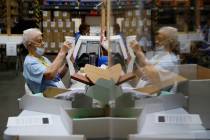 Election workers process mail-in ballots during a nearly all-mail primary election in Las Vegas ...