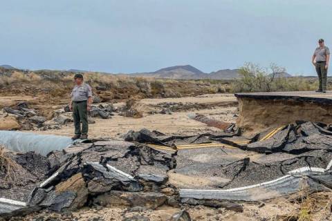 Park officials survey a road damaged by recent floods in Mojave National Preserve in August 202 ...