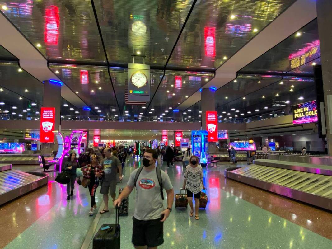 Travelers walk through Harry Reid International Airport in Las Vegas on August 14, 2022.