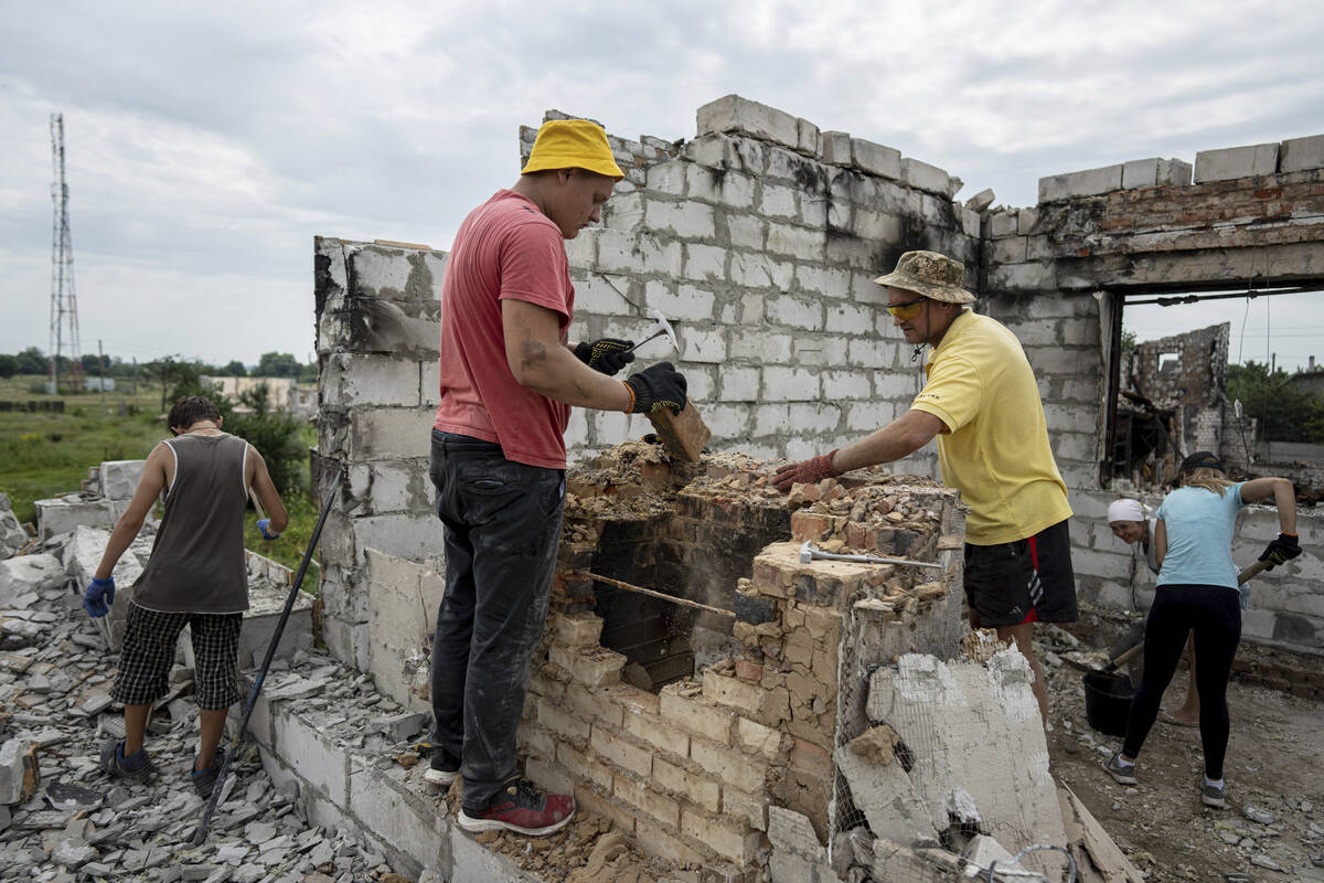 Volunteers clear rubbish on the second floor of Zhanna and Serhiy Dynaeva's house which was des ...