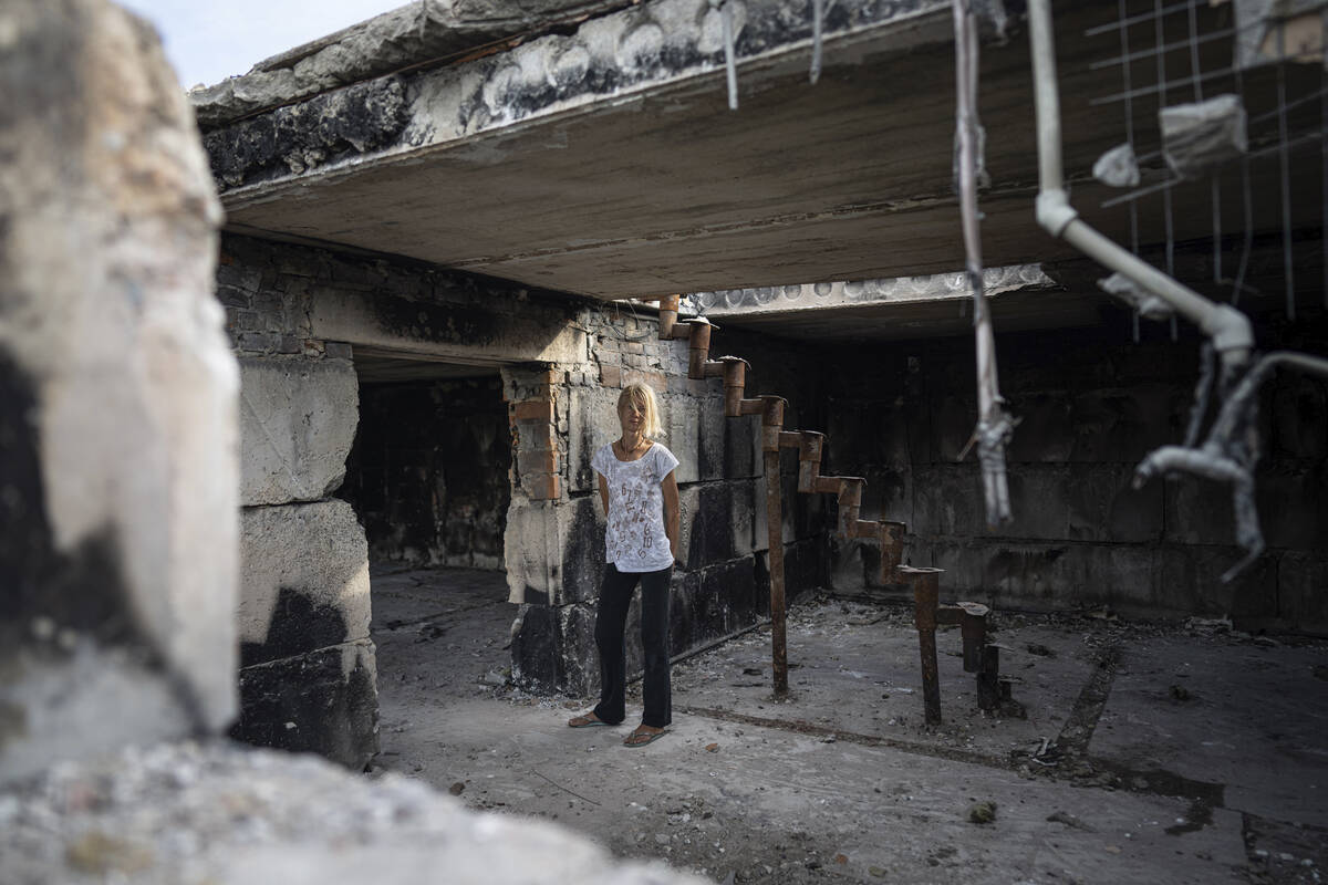 Zhanna Dynaeva stands inside her house which was destroyed by Russian bombardment, in the villa ...