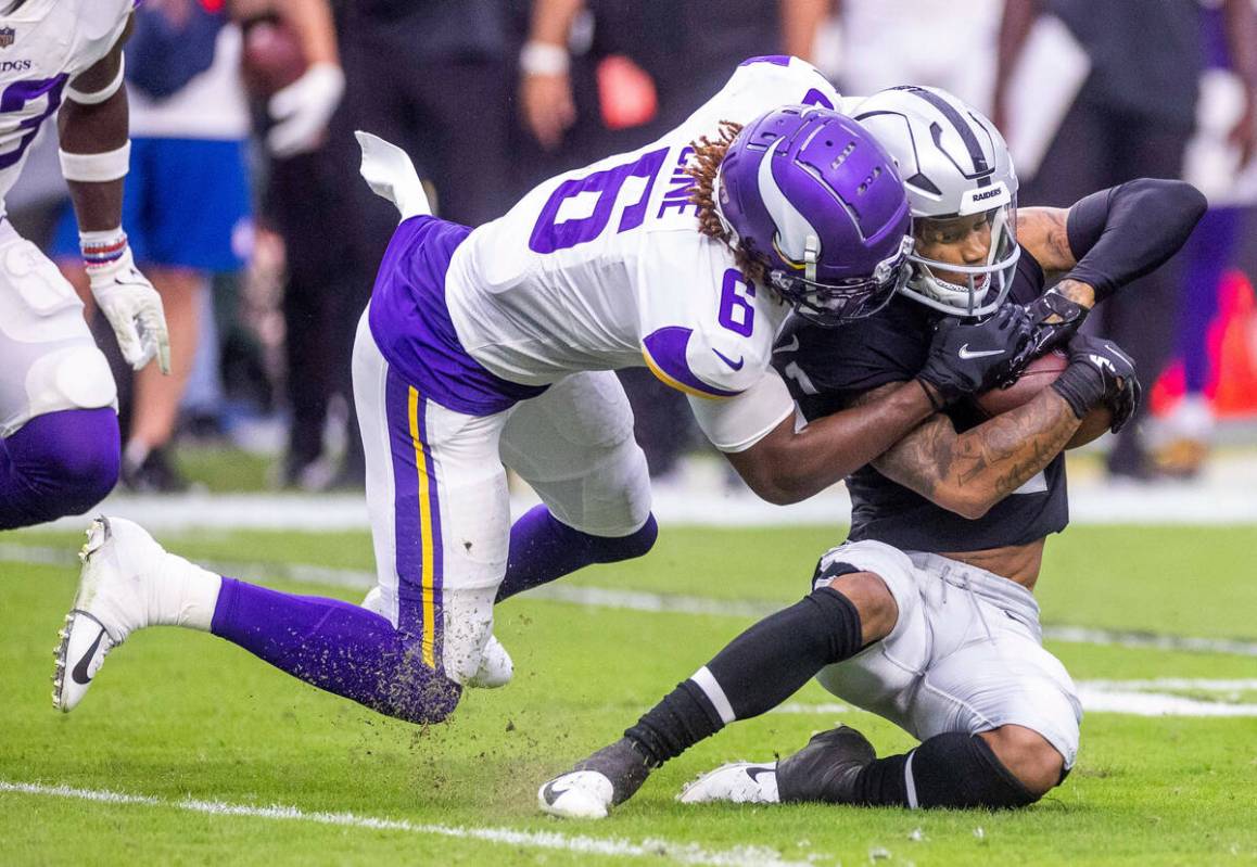 Vikings safety Lewis Cine (6) wraps up Raiders wide receiver Tyron Johnson (1) after a catch du ...
