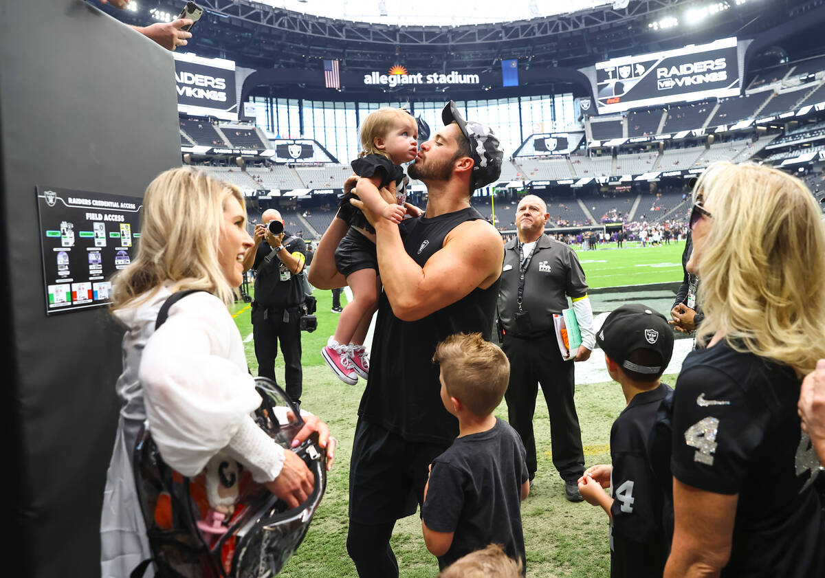Raiders quarterback Derek Carr kisses his daughter Brooklyn while visiting with his family befo ...