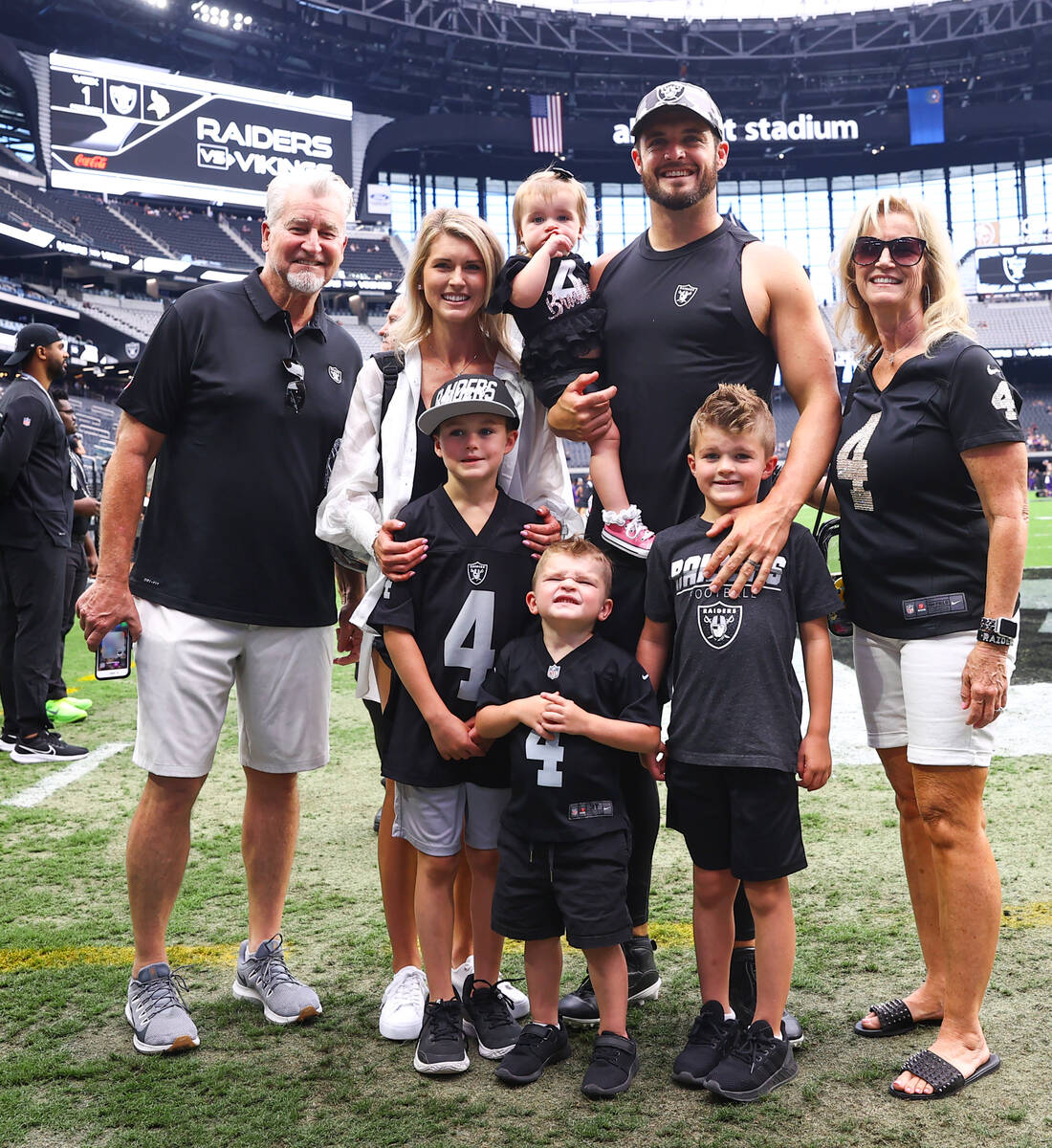 Derek Carr poses for photos with his family before the start an NFL preseason football game aga ...