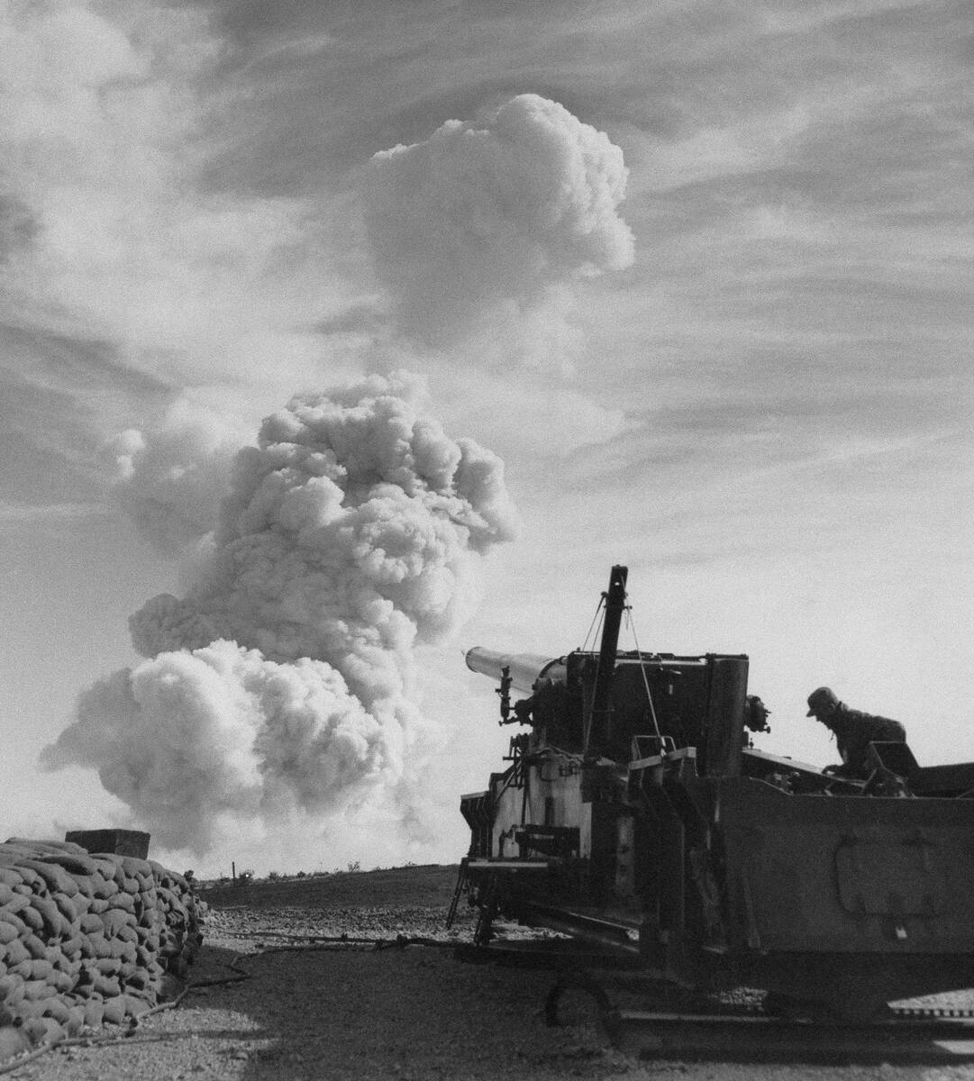 A boiling column of smoke rises in the distance seven miles away from one of the army's 280-mm ...