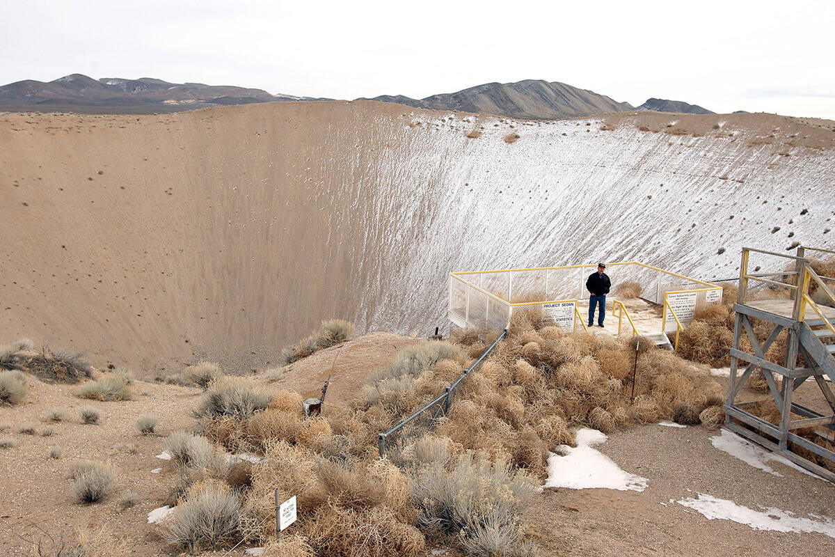Nevada Test Site historian Ernie Williams stands on the observation deck for the Sedan crater, ...