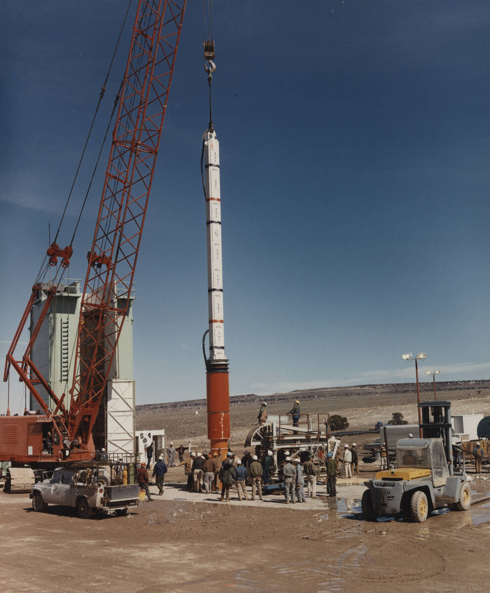 A nuclear explosive and diagnostic canister for a test named "Handley" is lowered down hole at ...