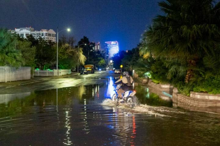 A motorcyclist rides through the flooded South Sixth Street at Sweeney Avenue on Thursday, July ...