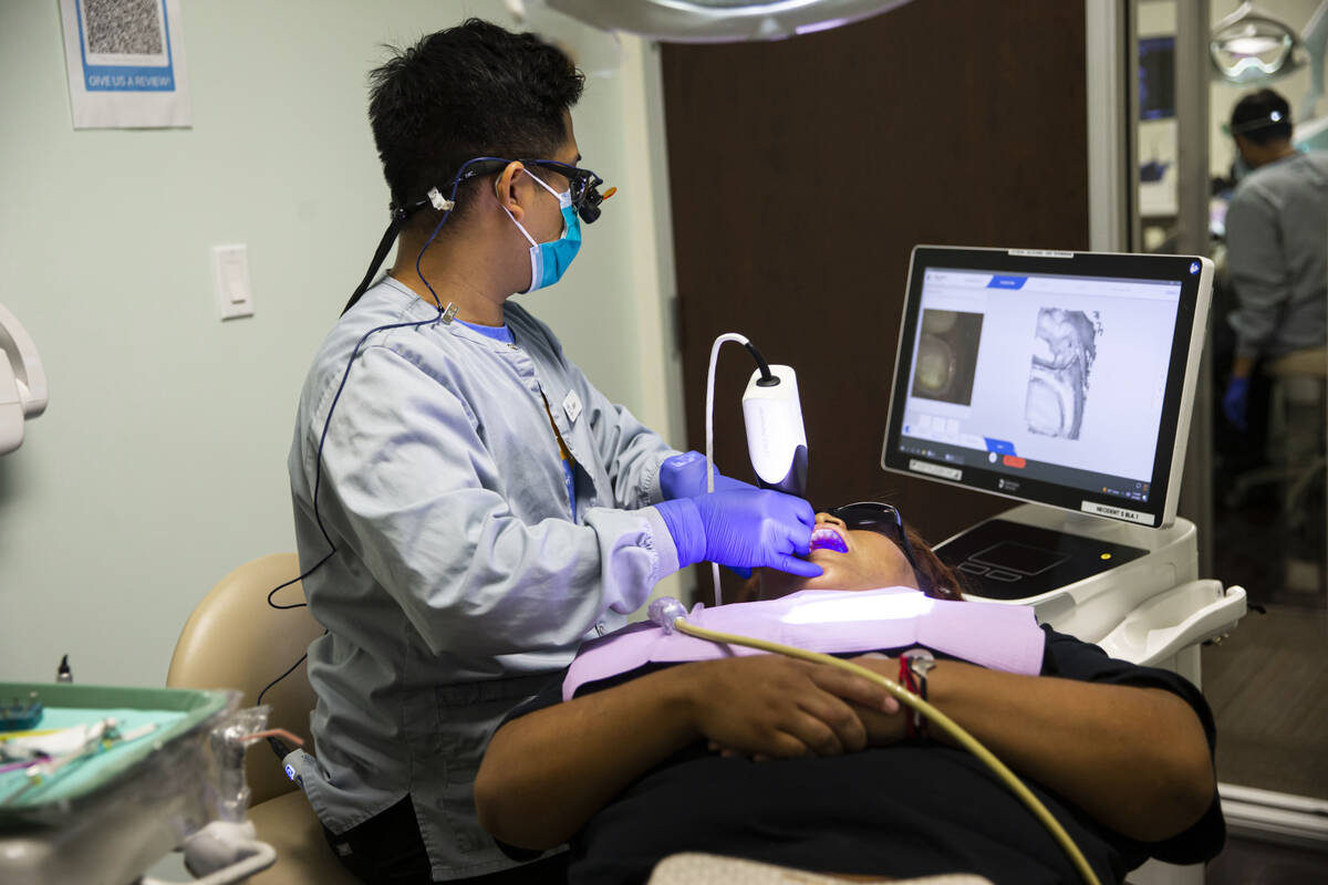 Dental assistant Jason Saavedra works with patient and recent Clark High School graduate Josely ...