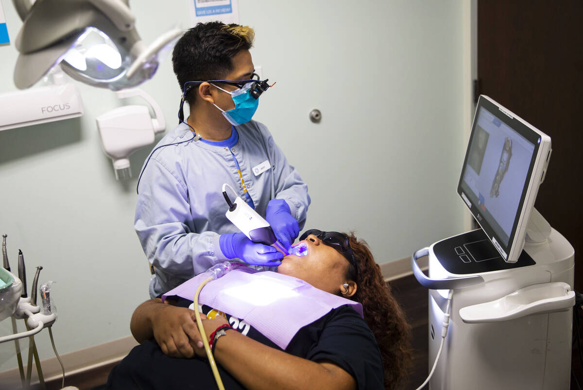 Dental assistant Jason Saavedra works with patient and recent Clark High School graduate Josely ...