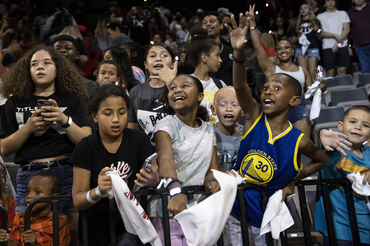 Young Las Vegas Aces fans cheer for their team after they won a WNBA playoff basketball game ag ...