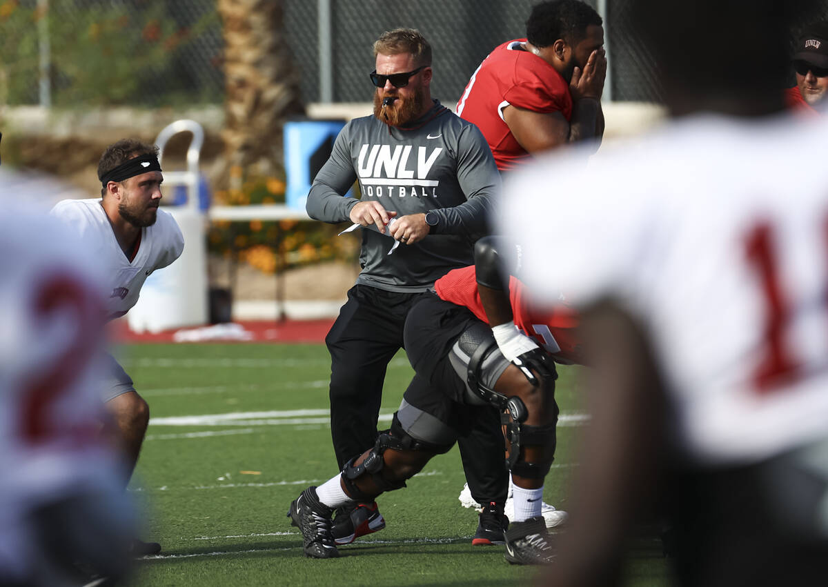 UNLV football strength and conditioning coach Matt Fyle leads team warmups during football prac ...