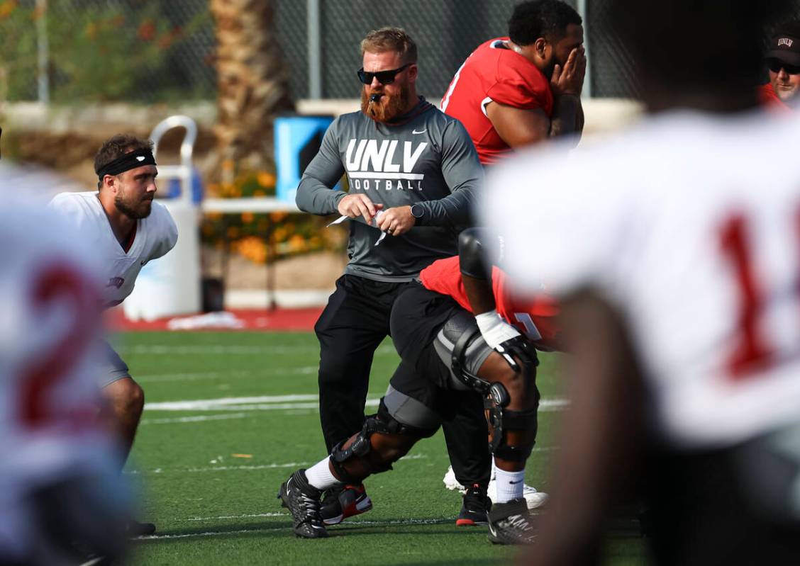 UNLV football strength and conditioning coach Matt Fyle leads team warmups during football prac ...