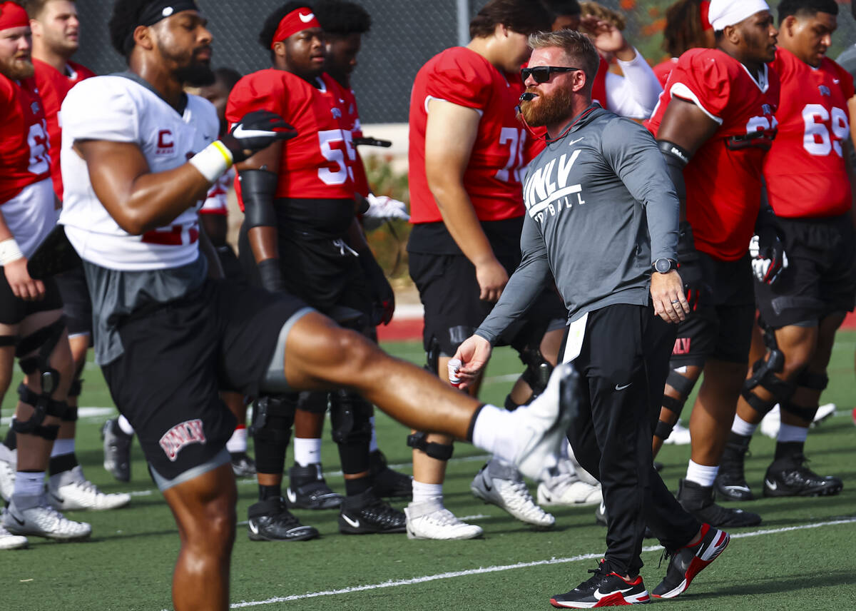 UNLV football strength and conditioning coach Matt Fyle leads team warmups during football prac ...