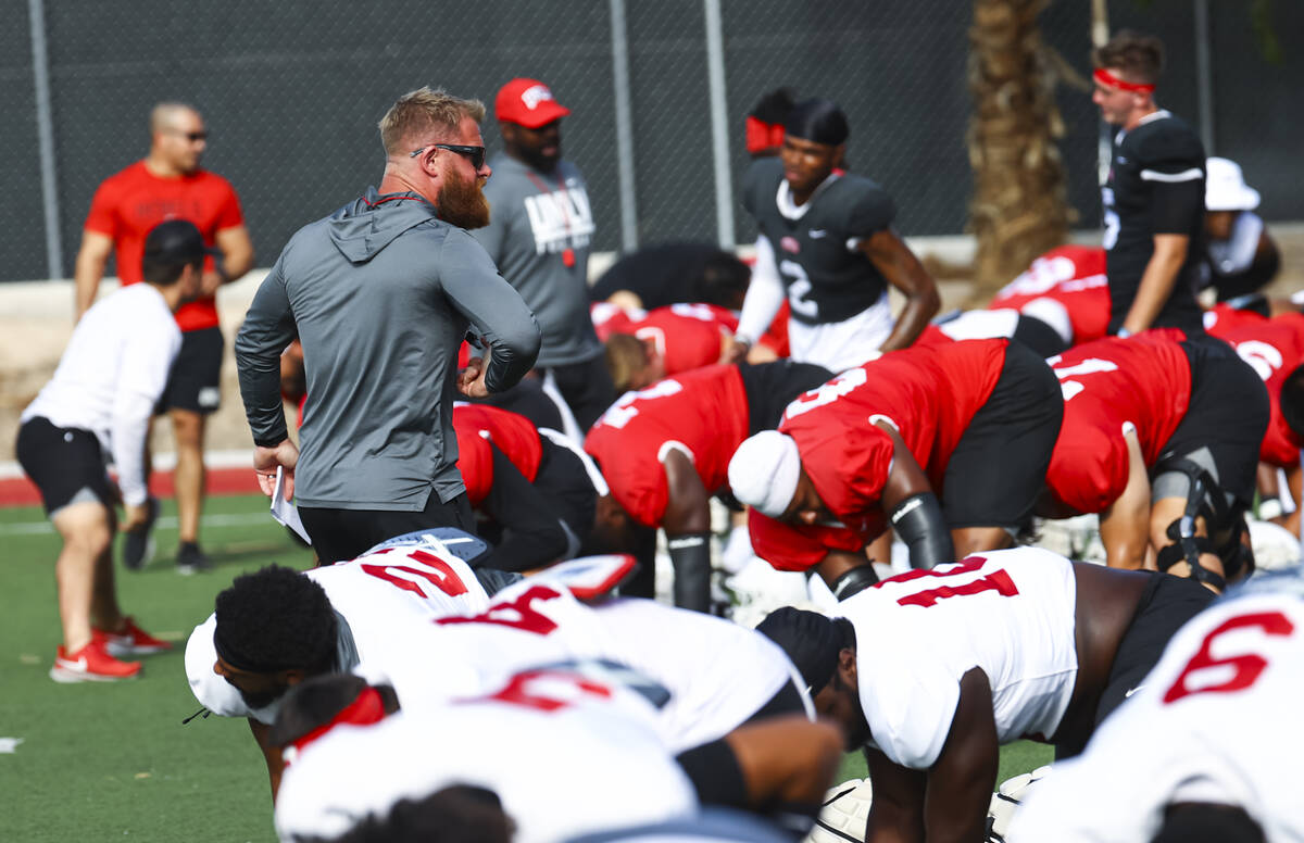 UNLV football strength and conditioning coach Matt Fyle leads team warmups during football prac ...