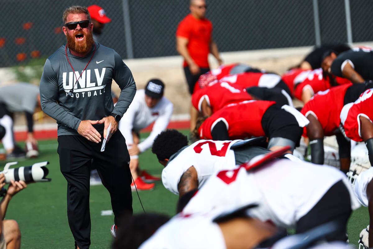 UNLV football strength and conditioning coach Matt Fyle leads team warmups during football prac ...