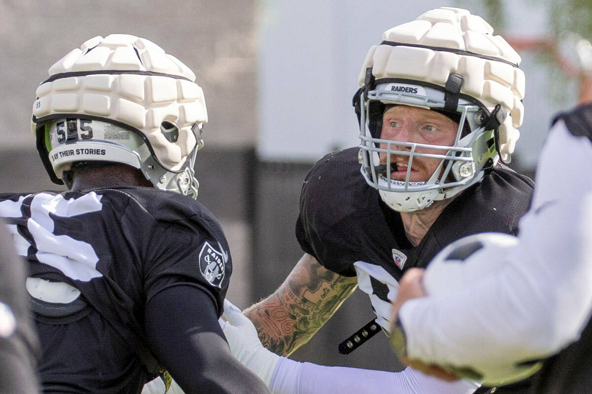 Raiders defensive end Maxx Crosby (98) works against defensive end Chandler Jones (55) during t ...