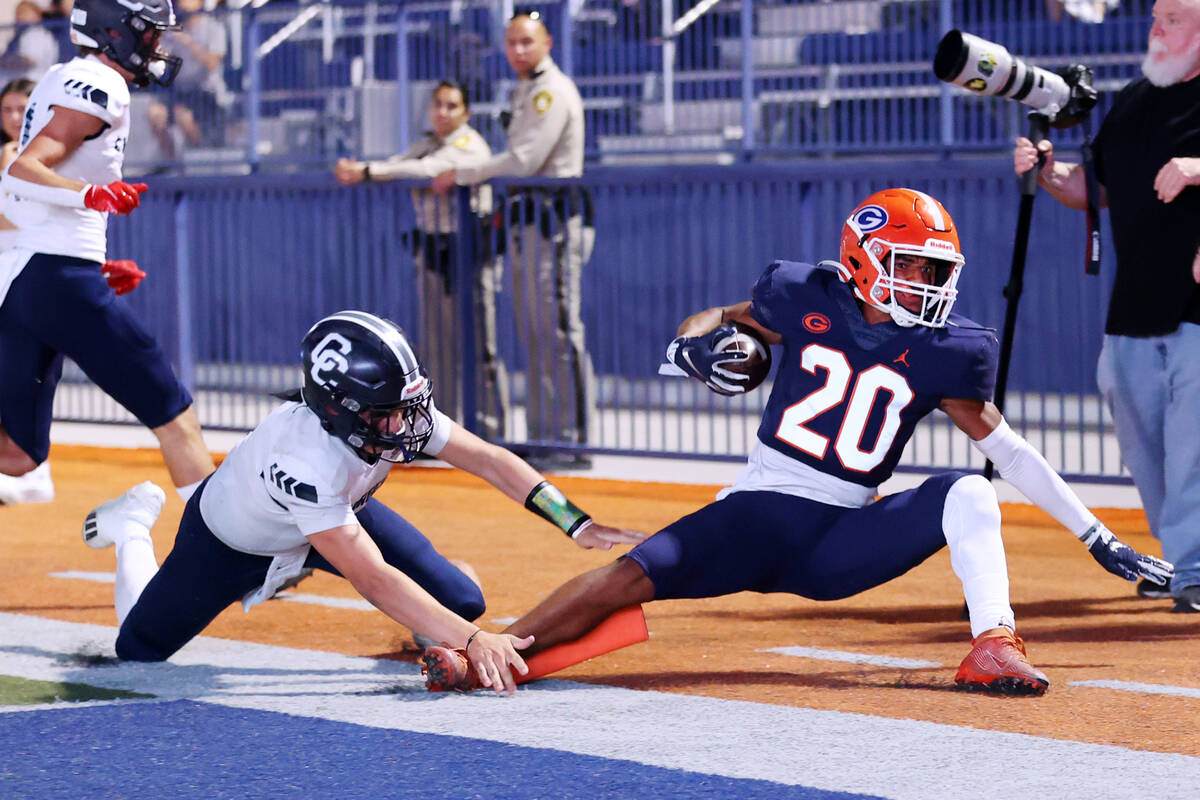 Bishop Gorman's Elija Lofton (20) is tackled by Corner Canyon's Issac Wilson (1) at the end zon ...