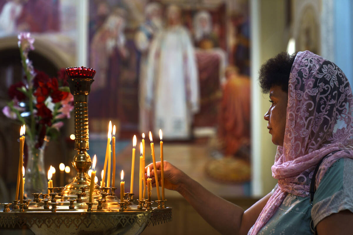 A parishioner lights a candle on the annual holiday of the Apple Feast of the Saviour at Saint- ...