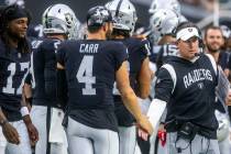 Raiders quarterback Derek Carr (4) slaps hands with head coach Josh McDaniels after a score dur ...