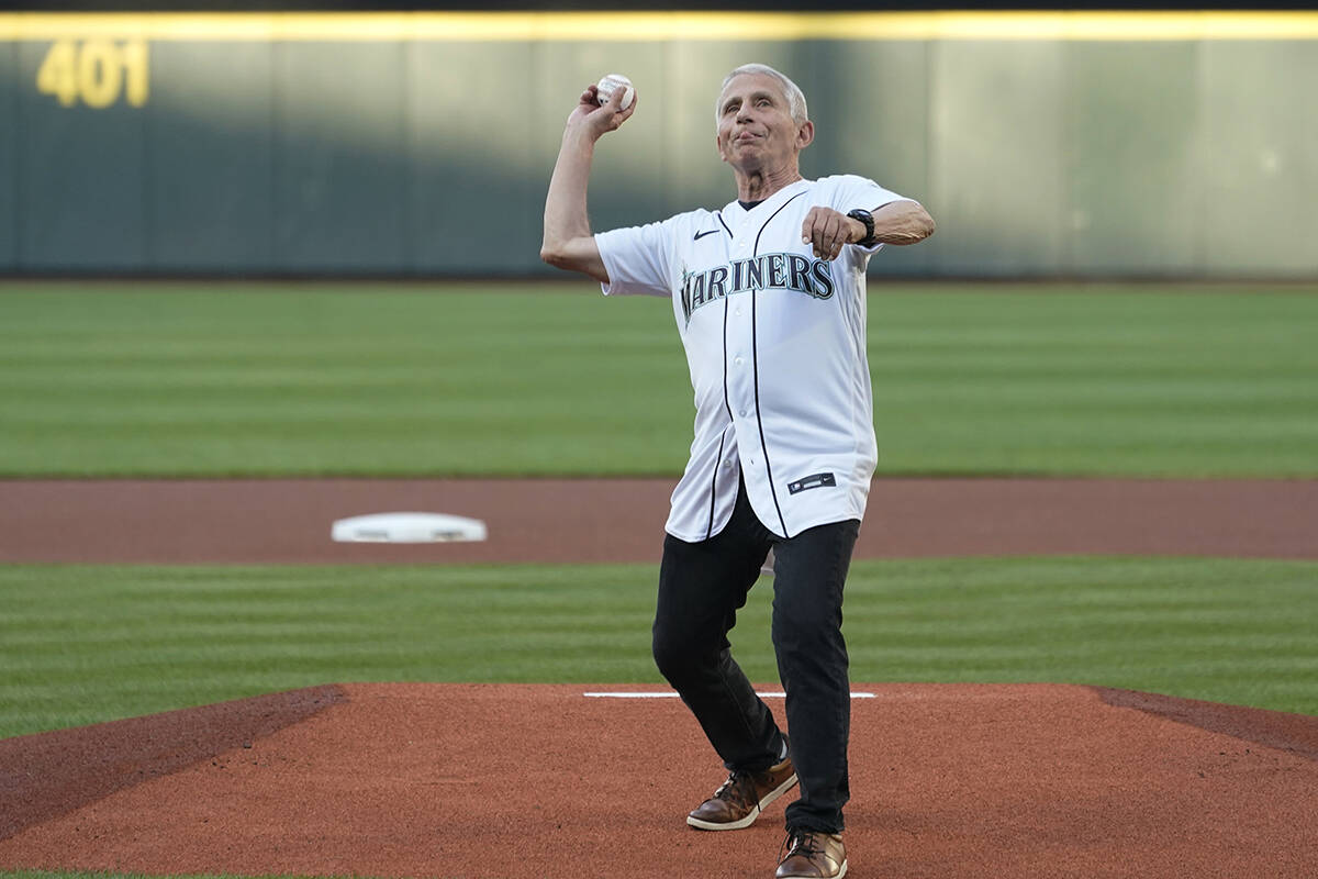 Dr. Anthony Fauci throws out the first pitch before a baseball game between the Seattle Mariner ...