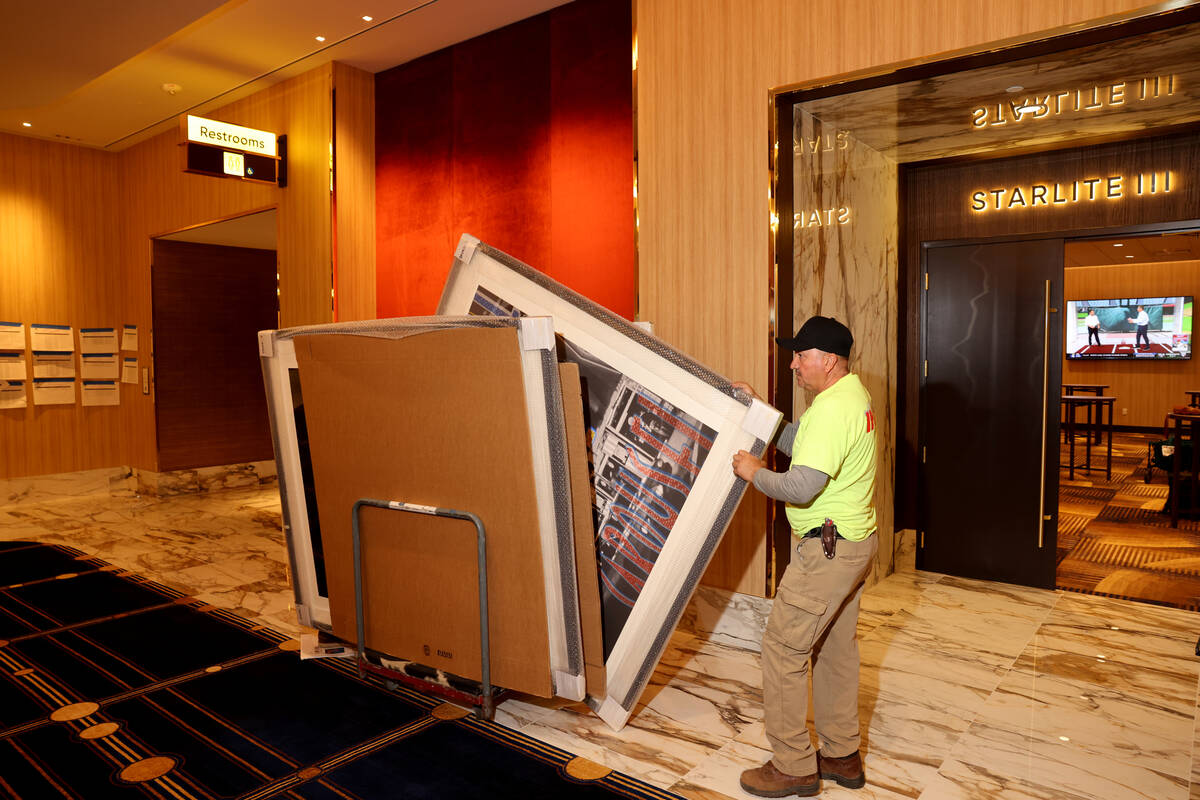 Workers put the finishing touches on the pre-function area at the new meetings and conventions ...