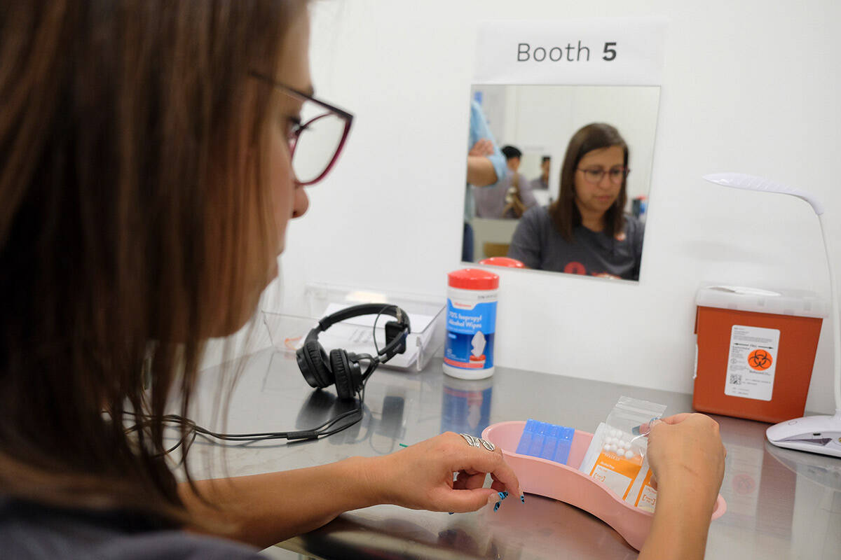 Volunteer Rachele Huennekens sits at a booth injection station at Safer Inside, a realistic mod ...