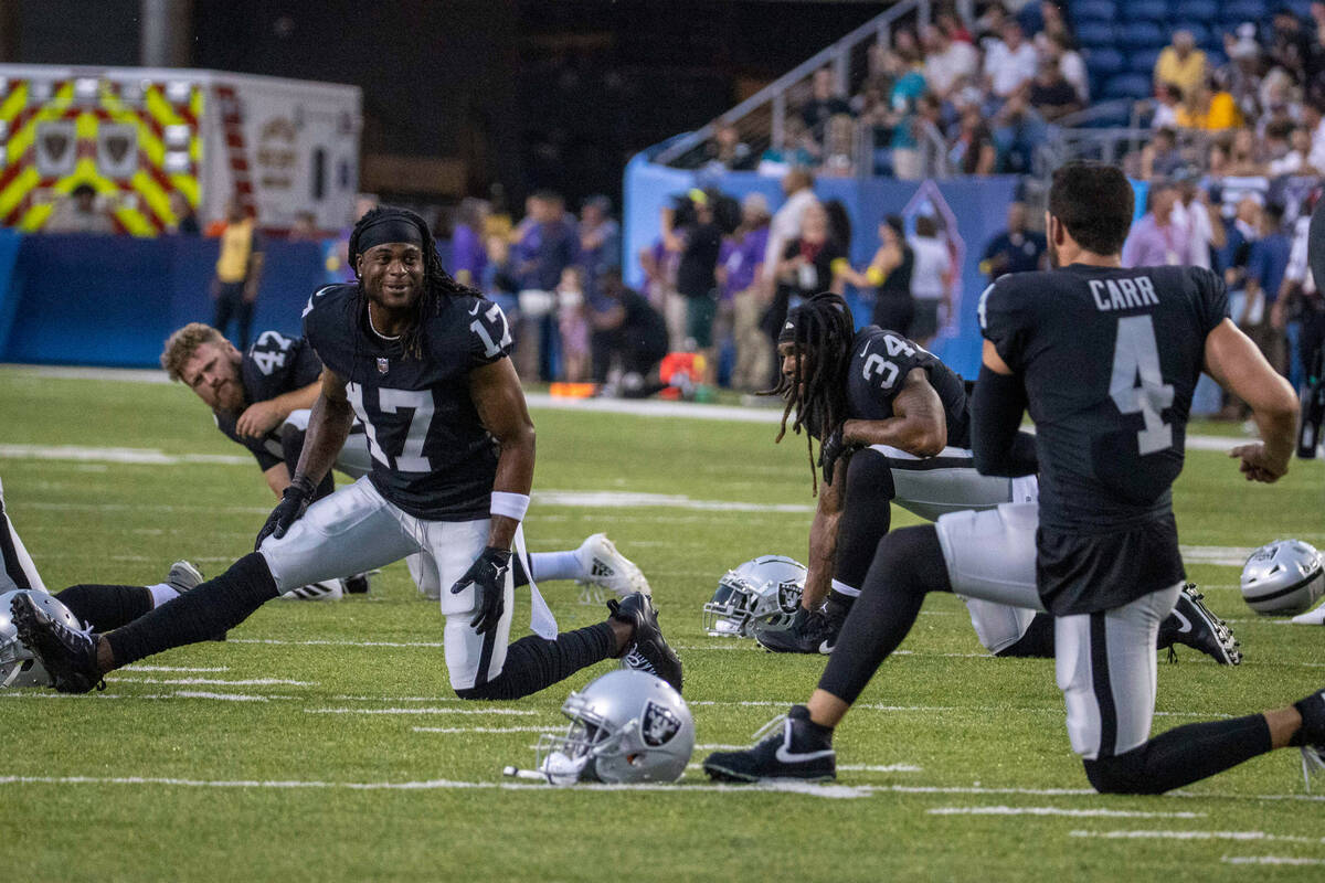 Raiders wide receiver Davante Adams (17) and Raiders quarterback Derek Carr (4) engage as they ...