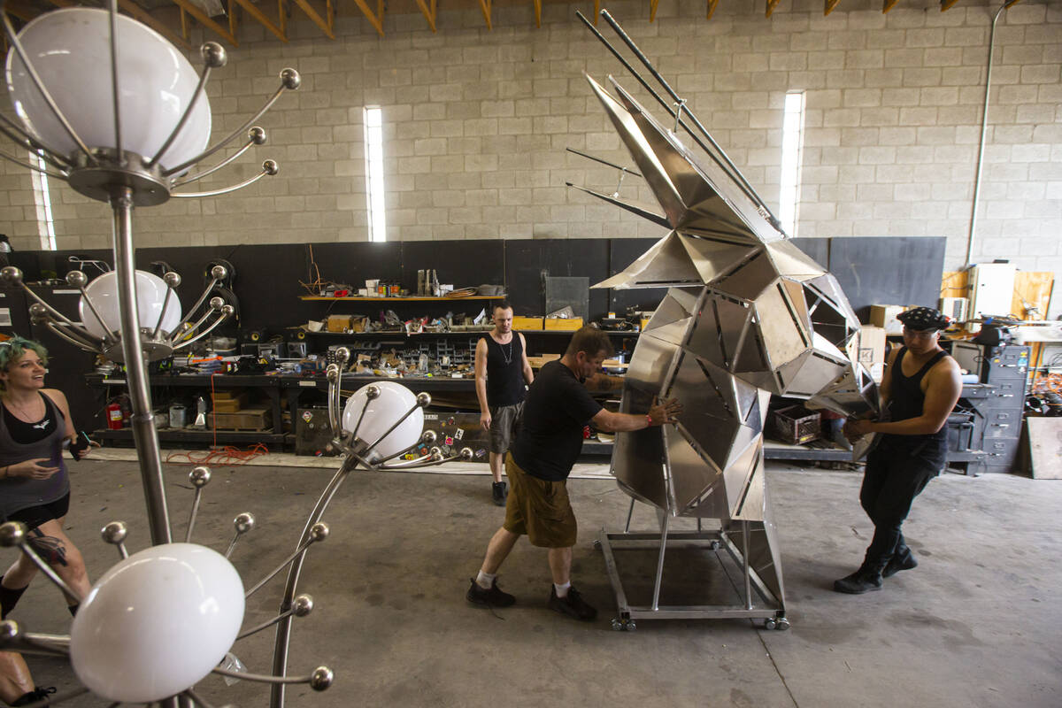 Crew members move the the head outside to be mountaed on The Metaphoenix art car, in preparatio ...