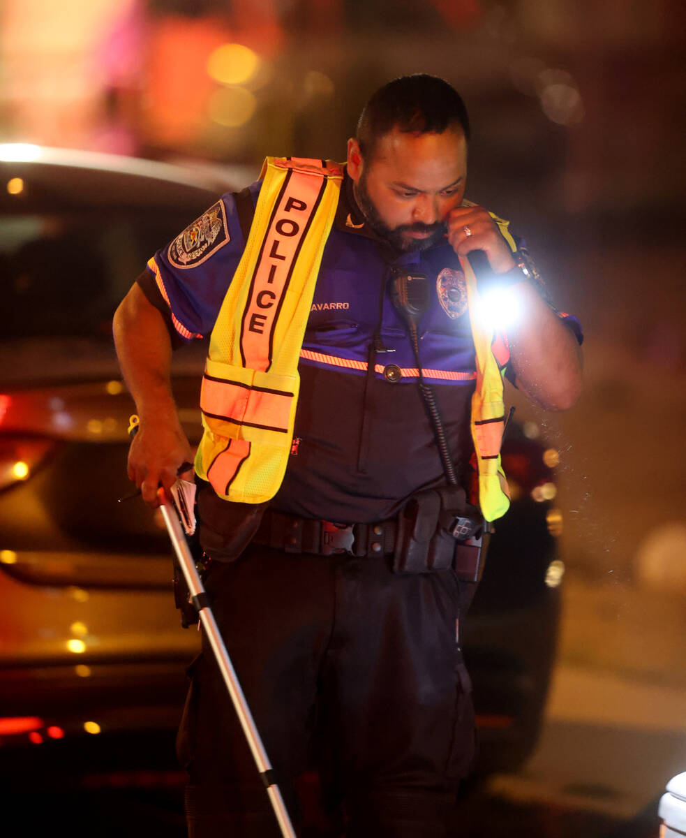 North Las Vegas Police Officer Andy Navarro, fatal traffic investigator, shines his flashlight ...